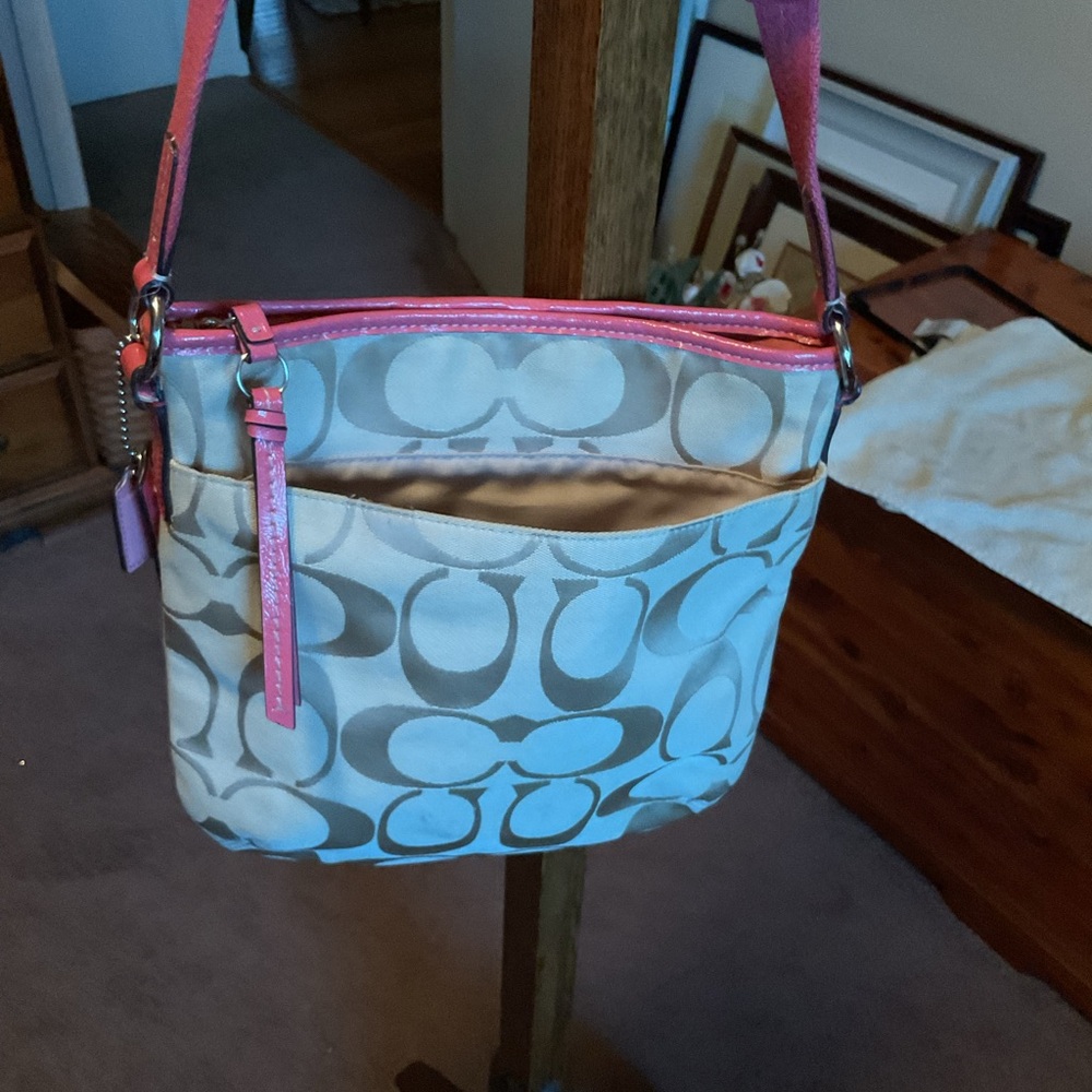 Stylish Pink and tan Women's Coach Bag with long adjustable shoulder strap.